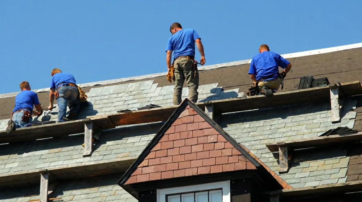 Roof replacement in progress with a team of professional contractors installing new shingles on a residential home in Stamford, CT